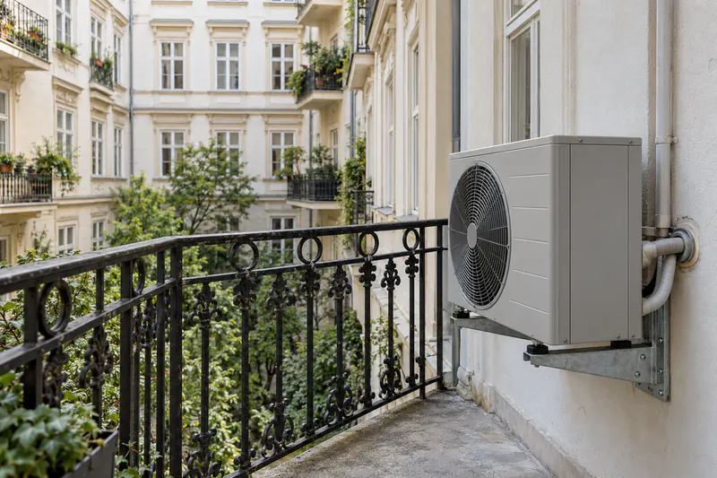 Wärmepumpen-Außengerät am Balkon einer Wiener Wohnung